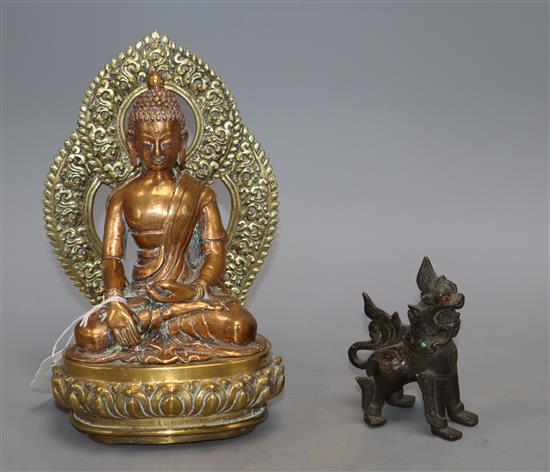 A Sino Tibetan bronze figure of Buddha Shakyamuni and a Thai lion dog